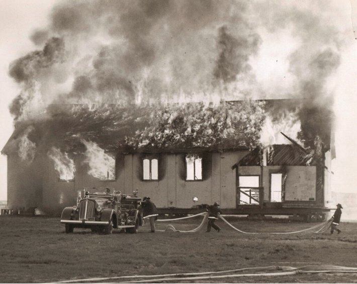 Historical photo of firefighters putting out a residential fire